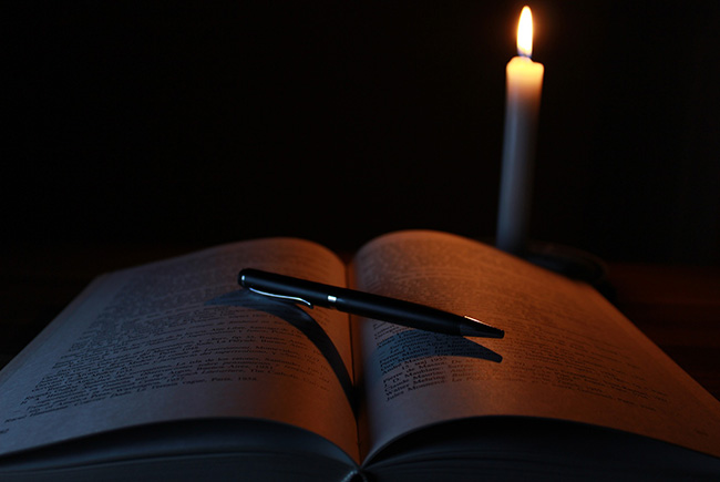 Bild på en bok och ett ljus.