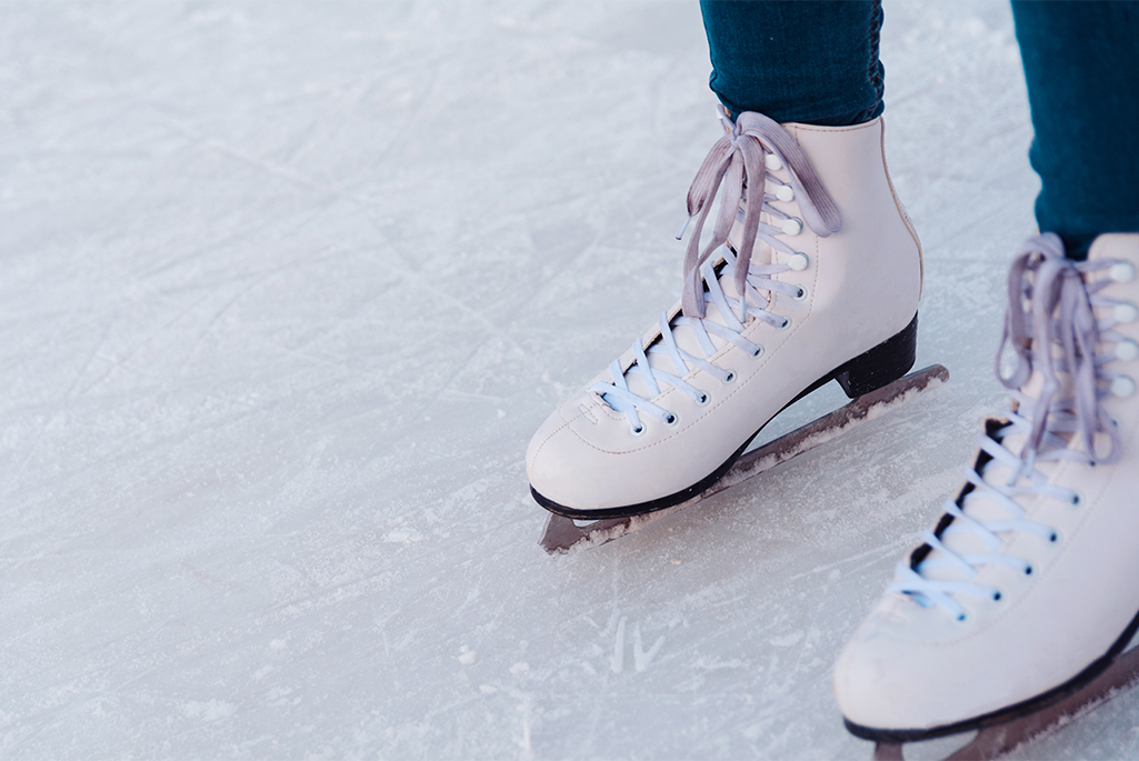 Två fötter som åker skridskor på en is.
