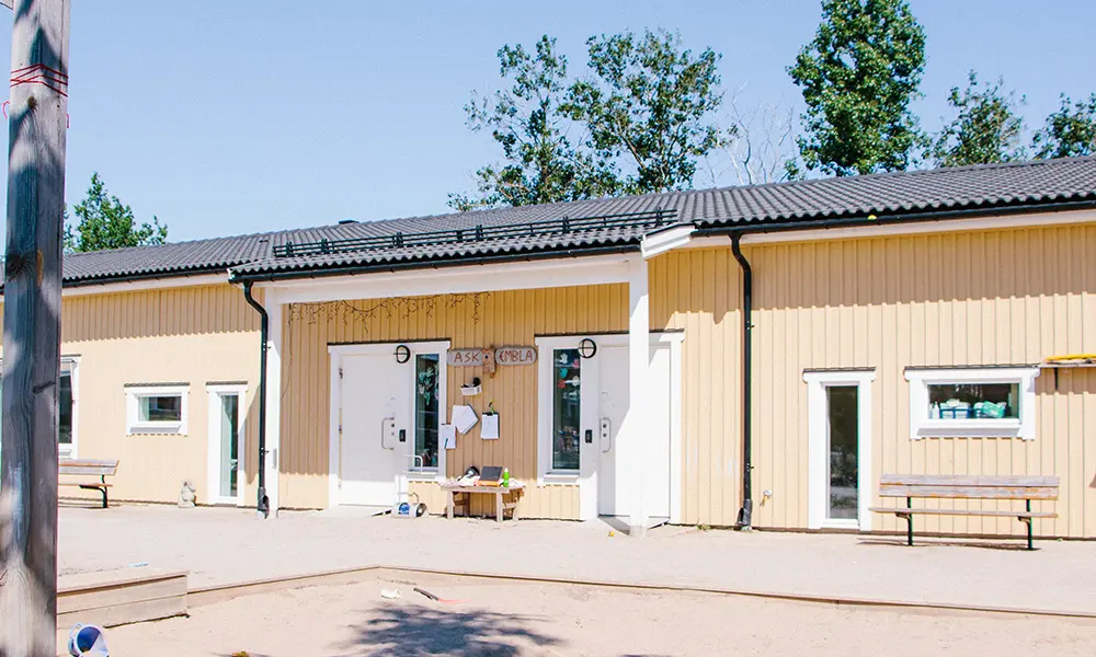 Foto på Skolsta förskola. Det är ett gult trähus med vita detaljer